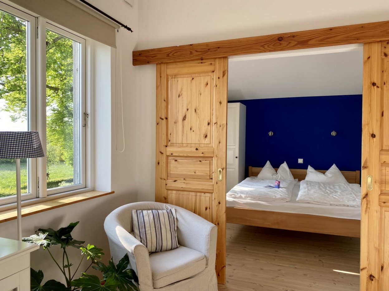 Schlafzimmer in einem Ferienapartement, Doppelbett hinter Holzschiebetür